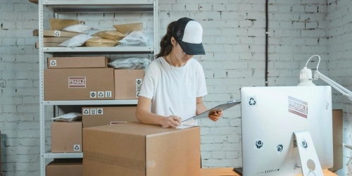 Señora apuntando cosas de cajas